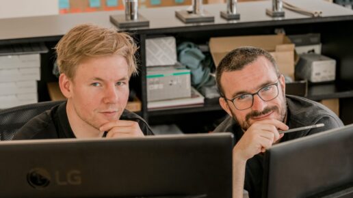 Two Vetica experts in front of computer screens in a creative workspace.