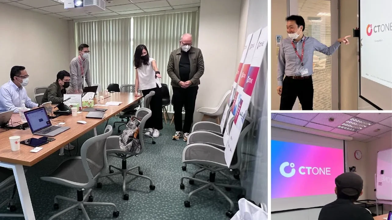 CTOne-Team im Konferenzraum, Vortragender zeigt Folie, Teilnehmende mit Laptops und Masken