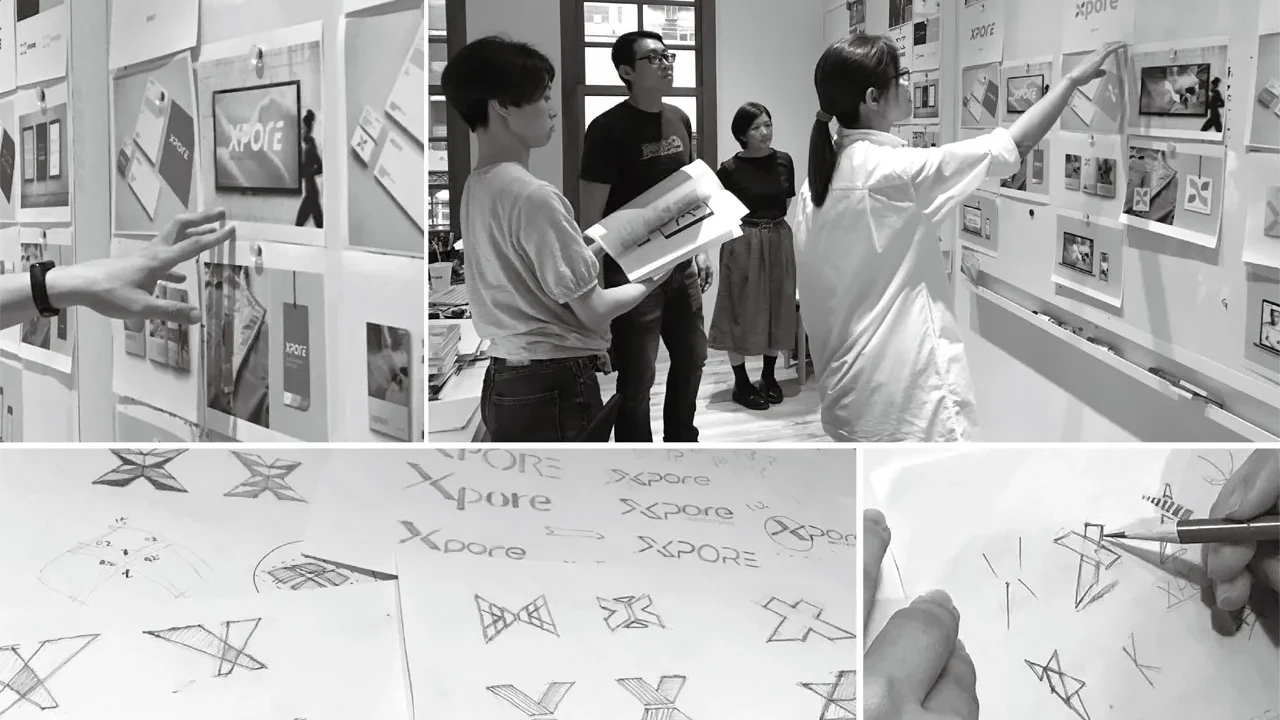 Designteam im Atelier betrachtet Xpore-Logo-Skizzen und Moodboard an der Wand