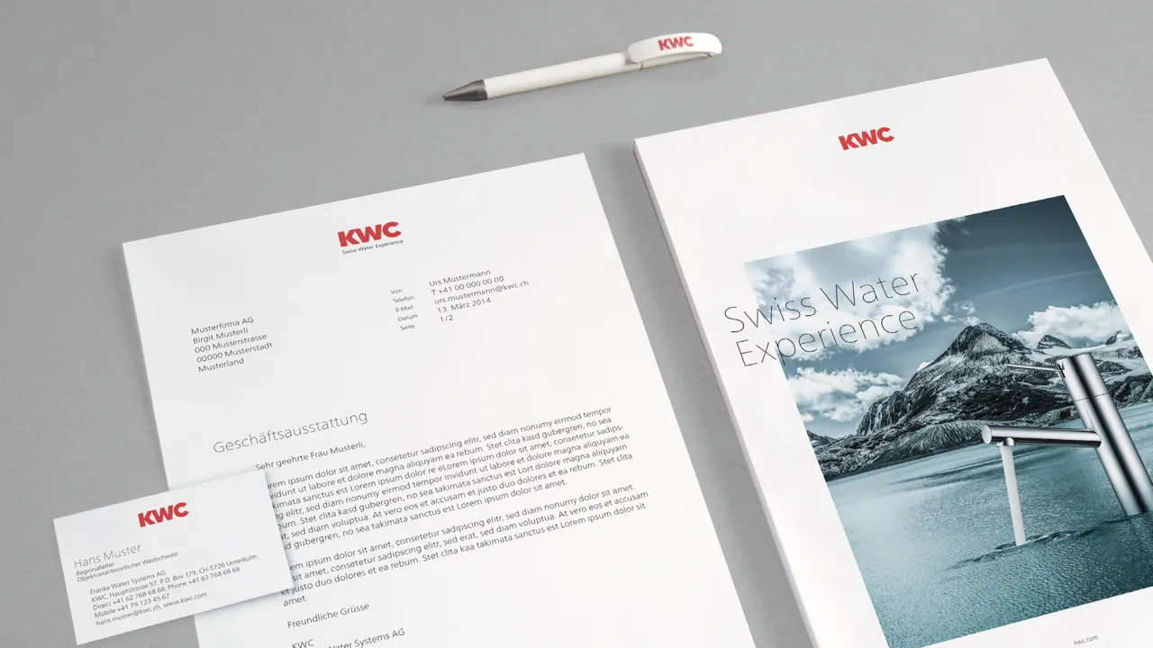 KWC corporate letterhead, business card, branded pen, and presentation folder on a grey background