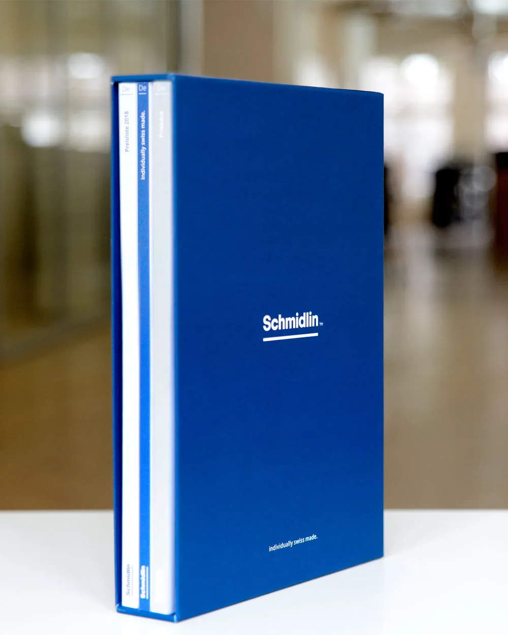 Blaue Schmidlin Schiebekassette im Hochformat mit eingesteckten Produktkatalogen und Preislisten