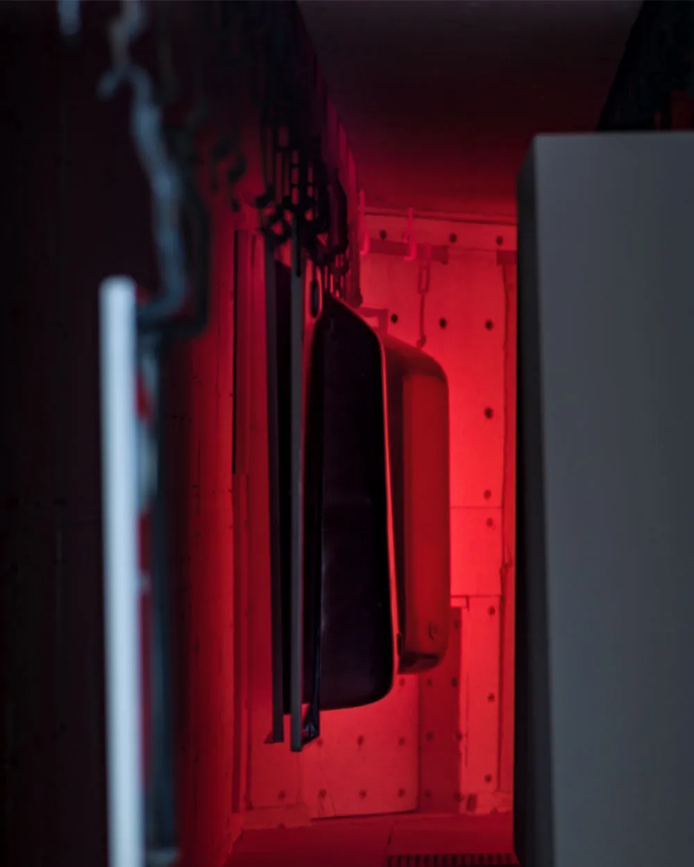 Blick in den rot glühenden Brennofen mit aufgehängten Stahl-Badewannen während des Emaillierungsprozesses