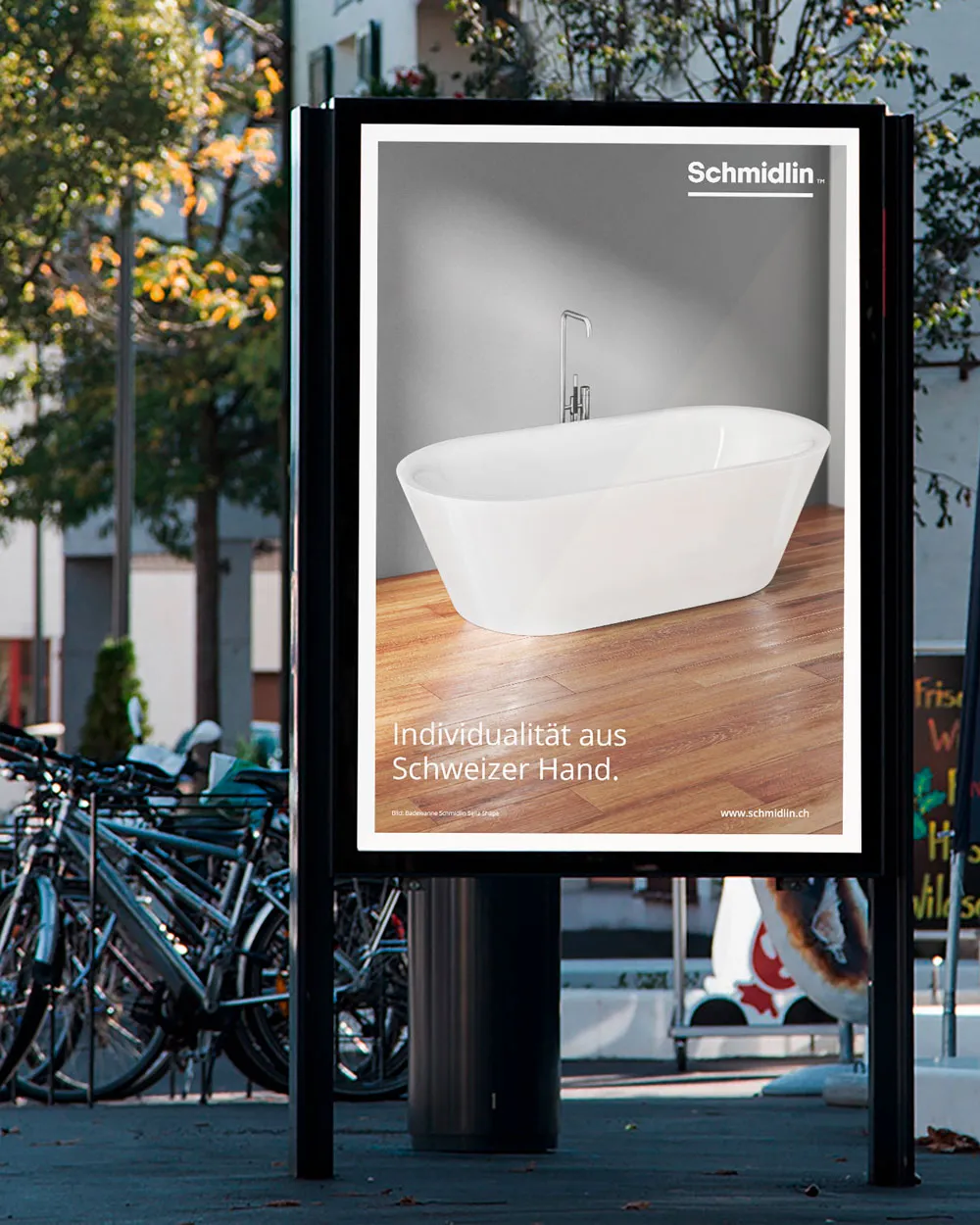Beleuchteter Plakatwechsler im Aussenbereich zeigt Schmidlin Freistehende Badewanne mit dem Slogan Individualität aus Schweizer Hand