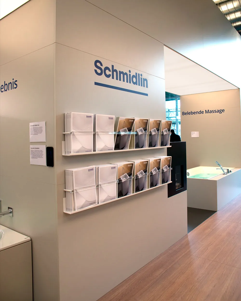 Wandmontierter Katalogständer auf dem Schmidlin Messestand mit sortierten Preislisten und Produktbroschüren