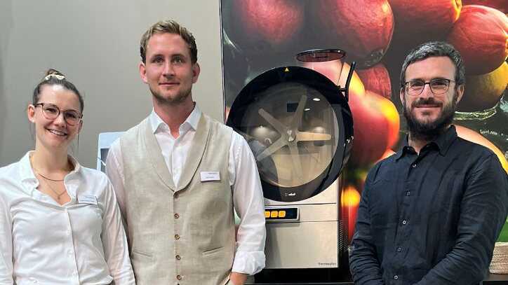 VETICA Team neben einer professionellen Kaffeemaschine auf einer Fachmesse