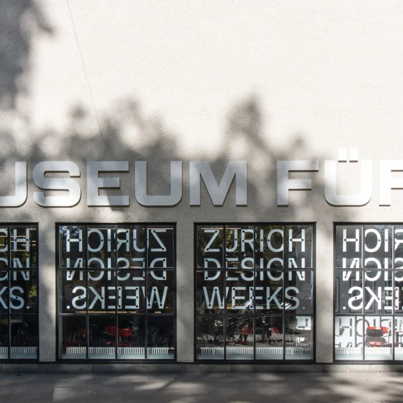 Aussenfassade des Museum fuer Gestaltung Zuerich mit grossen Fensterscheiben, auf denen